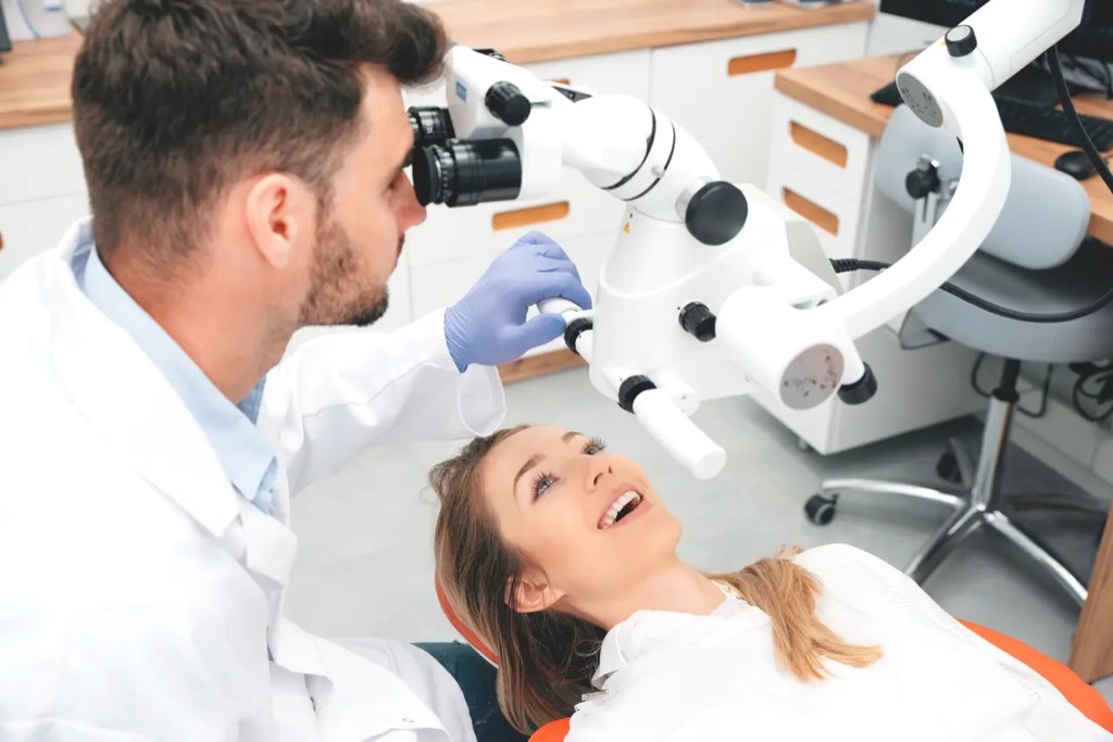 Cirujano examinando a una paciente con un microscopio quirúrgico